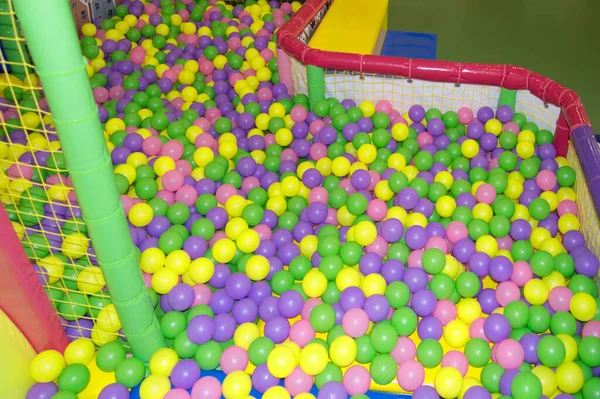Palline colorate in plastica multicolore nel parco giochi, piscina con palline per lo sviluppo dei bambini e giochi — Foto Stock