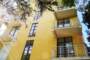 Modern, lüks, sarı bir tatil köyü balkonlu, güneşli bir yaz günü.