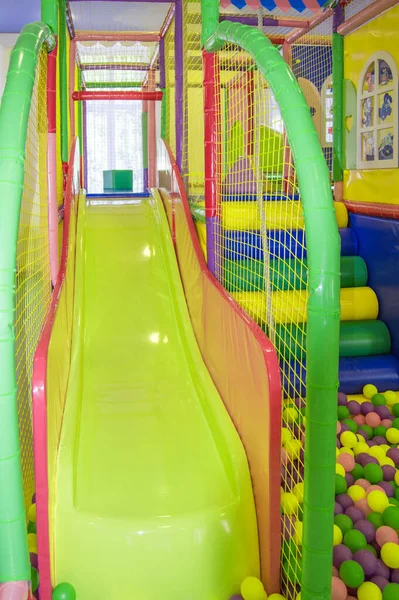 遊び場でメッシュとカラフルなボールを持つカラフルなプラスチックスライド 屋内遊び場での子供の安全 — ストック写真