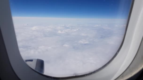 Vista dal finestrino di un aereo passeggeri che sorvola le nuvole. Guarda fuori dal finestrino dell'aereo. Il concetto di riposo, un viaggio di successo. Formato video 4K — Video Stock