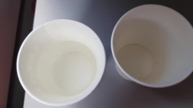 Temiz suyla doldurulmuş iki kağıt bardak, uçuşta beleş içkiler. Uçakla seyahat, içkilerle dolu bir masa, uçakta servis.