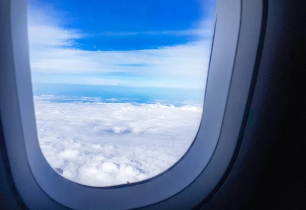 La vista desde la ventana redonda del avión sobre las blancas nubes de nieve, volando sobre las nubes, el concepto de libertad y viajes — Foto de Stock