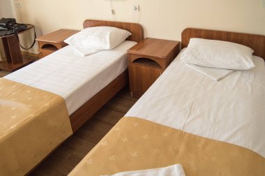 İki boş SINGLE yatak ve komodinli otel odası, otel işi konsepti.