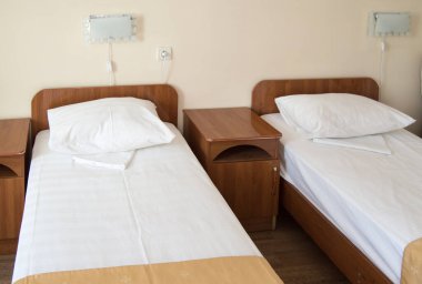 İki boş SINGLE yatak ve komodinli otel odası, otel işi konsepti.