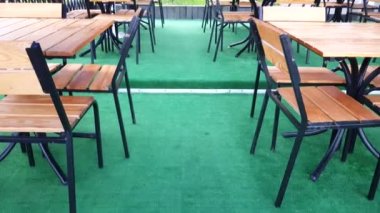 Boş bir kafede kameranın yavaş hareketi. Ahşap masalar, sandalyeler ve yeşil halı, 4 km video..