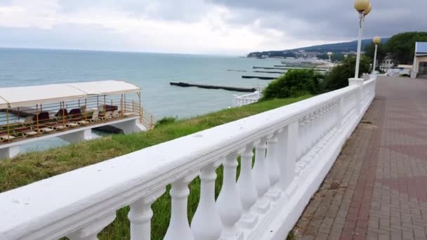 4K VIDEO, klasik beyaz balustrade, denizin arka planında. Şafak vakti güzel deniz manzarası bulutlu bir yaz gününde, ıssız bir sabah yürüyüşü. — Stok video