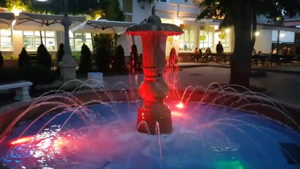 Mehrfarbige Einzelne Nacht Brunnen Auf Dem Hintergrund Eines Straßencafés Sommer — Stockvideo