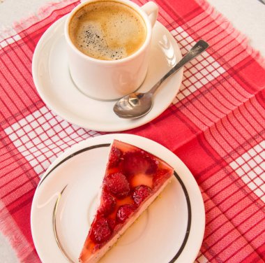Taze çilekli cheesecake ve çay tabağında kaşık olan bir fincan kahve, jöleli çilekli tatlı bir tatlının üst görüntüsü, lezzetli gurme kahvaltısı konsepti..