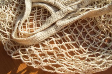 Yeniden kullanılabilir beyaz renkli boş bir alışveriş çantası. Sıfır atık kavramı, dokuma hücrelerinin arka planı, üst görünüm, yakın çekim.