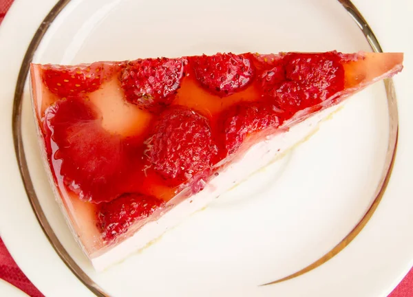 白いプレートにイチゴチーズケーキのおいしい作品 赤チェッカーナプキンとテーブルの上のビュー トップビュー — ストック写真