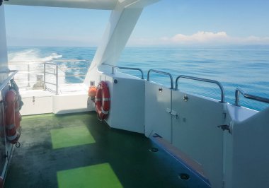 Lüks bir yatın güvertesinde bir can simidi, dalgalı bir deniz manzarası, deniz kenarında bir patika, suda bir tatil konsepti ve romantik bir yolculuk..
