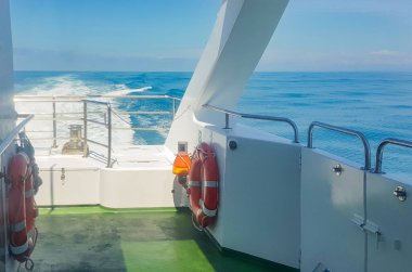 Lüks bir yatın güvertesinde bir can simidi, dalgalı bir deniz manzarası, deniz kenarında bir patika, suda bir tatil konsepti ve romantik bir yolculuk..