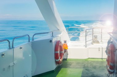 Lüks bir yatın güvertesinde bir can simidi, dalgalı bir deniz manzarası, deniz kenarında bir patika, suda bir tatil konsepti ve romantik bir yolculuk..