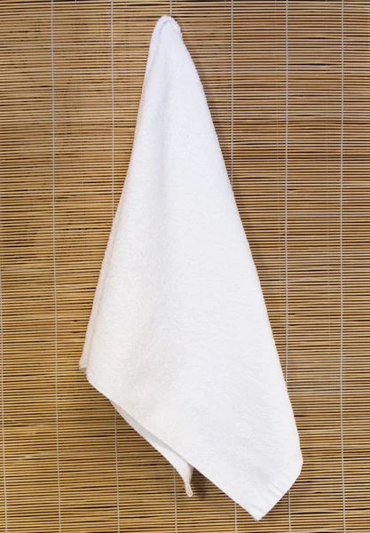 Καθαρό άσπρο πετσέτα που κρεμά σε φόντο μπαμπού — Φωτογραφία Αρχείου
