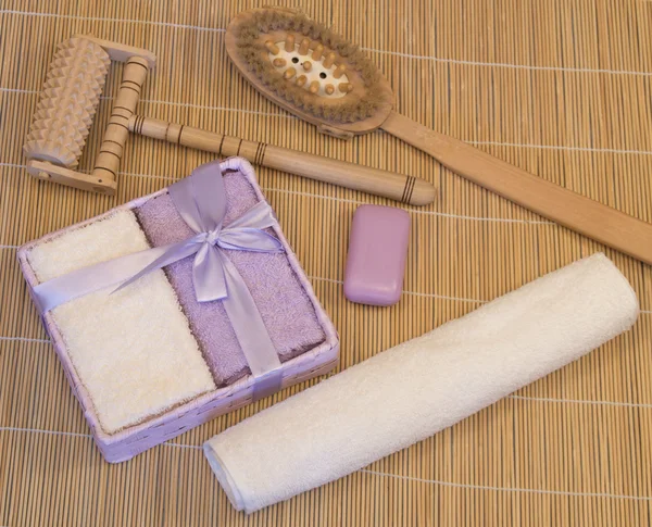 Badkar tillbehör, lila, beige handduk på bambu matta — Stockfoto