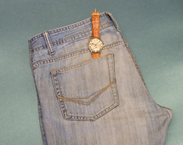 Jugend-Jeans mit einer Uhrentasche auf blauem Hintergrund — Stockfoto