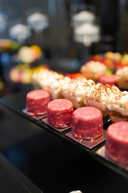 Various colorful desserts with berries, chocolate, and cream on display, a delicious sweet collection of pastries.