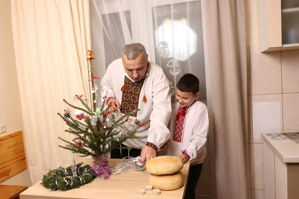 Ukrayna nakış işindeki bir adam ve oğlu Noel ağacı süslemişler..