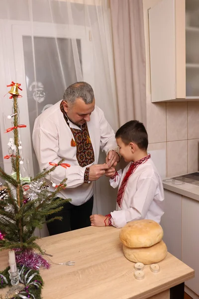 Ukrayna nakış işindeki bir adam ve oğlu Noel ağacı süslemişler..