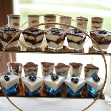 Mini desserts in transparent cups with cream for a festive buffet.        