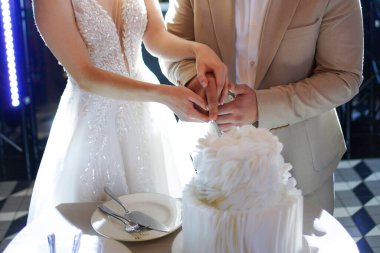 Yeni evliler düğün pastasını kesiyor. Düğün gelenekleri..
