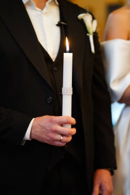 Yeni evliler düğün töreninde ellerinde mum tutuyorlar..