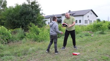 Çocuk, Green Park 'ta yetişkin koçuyla boks antrenmanı yapıyor..