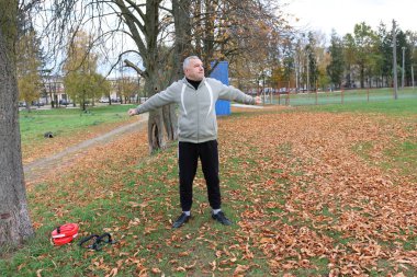 Bir adam antrenmana hazırlanıyor ve ısınıyor.