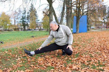 Bir adam antrenmana hazırlanıyor ve ısınıyor.