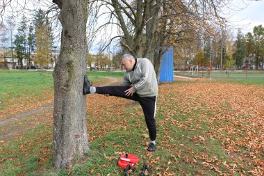 Bir adam antrenmana hazırlanıyor ve ısınıyor.