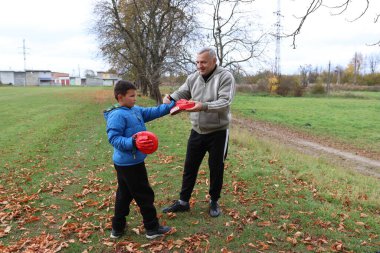 Bir adam ve bir çocuk antrenman eldivenleri üzerinde antrenman yapıyor ve pratik yapıyorlar.