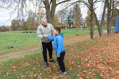 Bir adam ve bir çocuk antrenman eldivenleri üzerinde antrenman yapıyor ve pratik yapıyorlar.