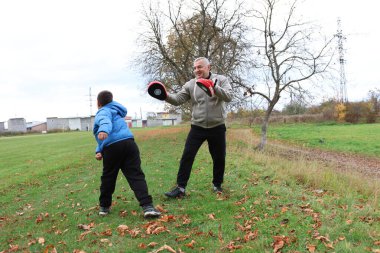 Bir adam ve bir çocuk antrenman eldivenleri üzerinde antrenman yapıyor ve pratik yapıyorlar.