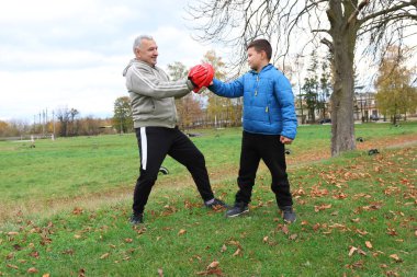 Bir adam ve bir çocuk antrenman eldivenleri üzerinde antrenman yapıyor ve pratik yapıyorlar.