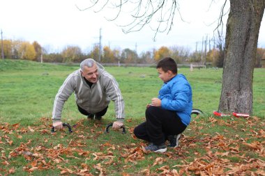 Bir adam ve bir çocuk antrenman eldivenleri üzerinde antrenman yapıyor ve pratik yapıyorlar.