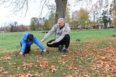 Bir adam ve bir çocuk antrenman eldivenleri üzerinde antrenman yapıyor ve pratik yapıyorlar.