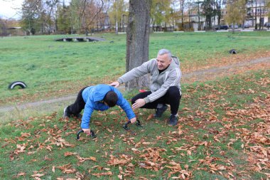 Bir adam ve bir çocuk antrenman eldivenleri üzerinde antrenman yapıyor ve pratik yapıyorlar.