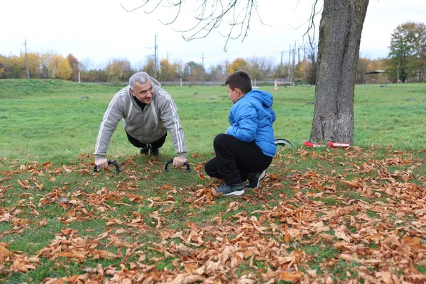Bir adam ve bir çocuk antrenman eldivenleri üzerinde antrenman yapıyor ve pratik yapıyorlar.