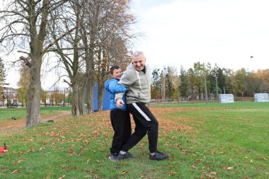 Bir adam ve bir çocuk antrenman eldivenleri üzerinde antrenman yapıyor ve pratik yapıyorlar.