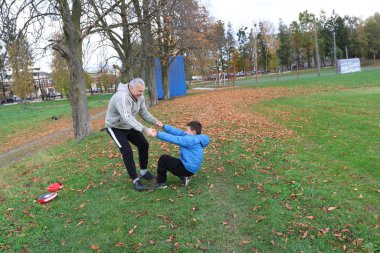 Bir adam ve bir çocuk antrenman eldivenleri üzerinde antrenman yapıyor ve pratik yapıyorlar.