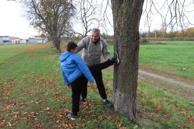 Bir adam ve bir çocuk antrenman eldivenleri üzerinde antrenman yapıyor ve pratik yapıyorlar.