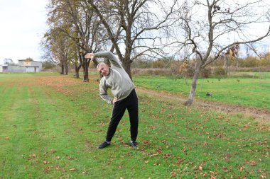 Bir adam antrenmana hazırlanıyor ve ısınıyor.