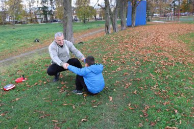 Bir adam ve bir çocuk antrenman eldivenleri üzerinde antrenman yapıyor ve pratik yapıyorlar.