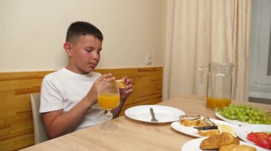 Bir çocuk masada oturuyor ve tatlı olarak dondurma yiyor..