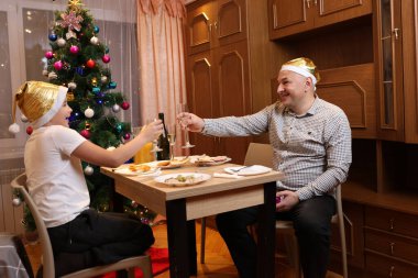 Baba oğul Noel 'i ya da yeni yılı bir şenlik masasında kutluyorlar.