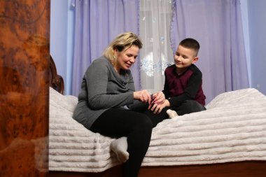 Anne oğullarının tırnaklarını nazikçe kesiyor, hijyene ve sağlığına dikkat ediyor..