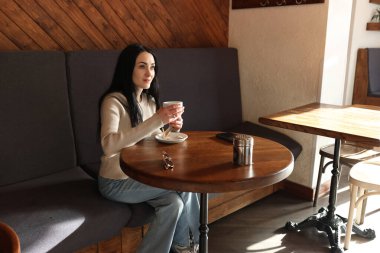 Bir kadın bir kafede kahve içiyor..