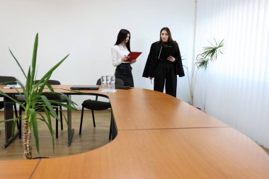 İki kız iş konuşmak ve kontrat imzalamak için ofiste buluşuyor..