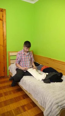 Bir çocuk yatakta oturur, elbiselerini katlar, odasını düzenler ve etrafındaki eşyaları düzgünce düzenler..