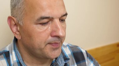 Adam masada otururken bardaktan maden suyu içiyor. Yakın plan.